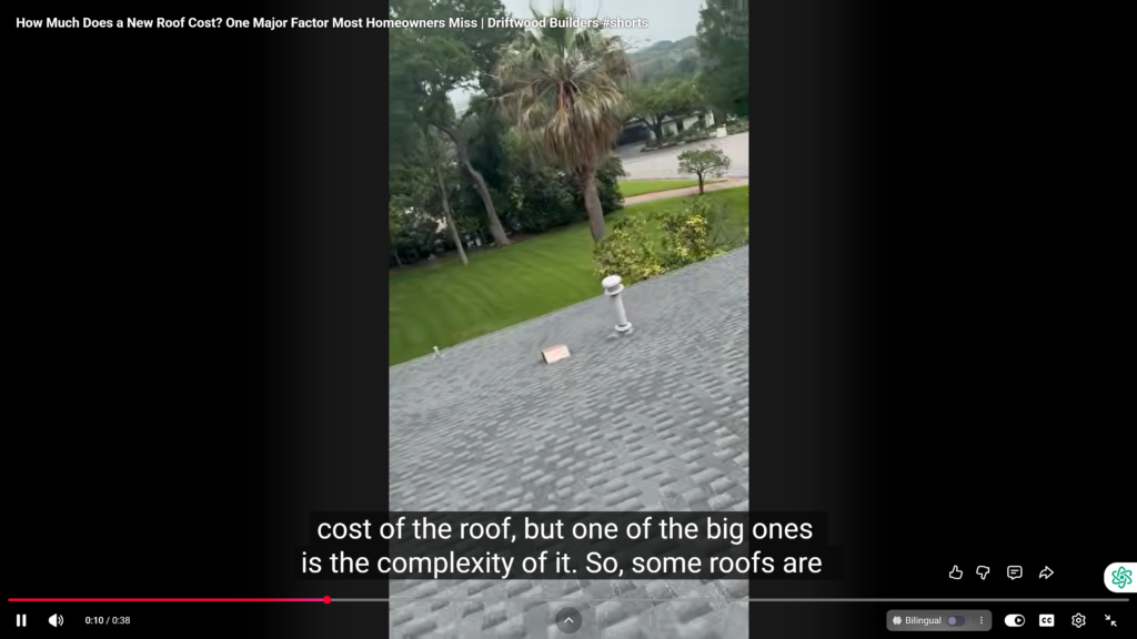 Screenshot from a video showing a gray shingled roof edge in the foreground, with green lawn, trees (including a palm) and a street in the background; white caption text about roofing costs is visible at the bottom.