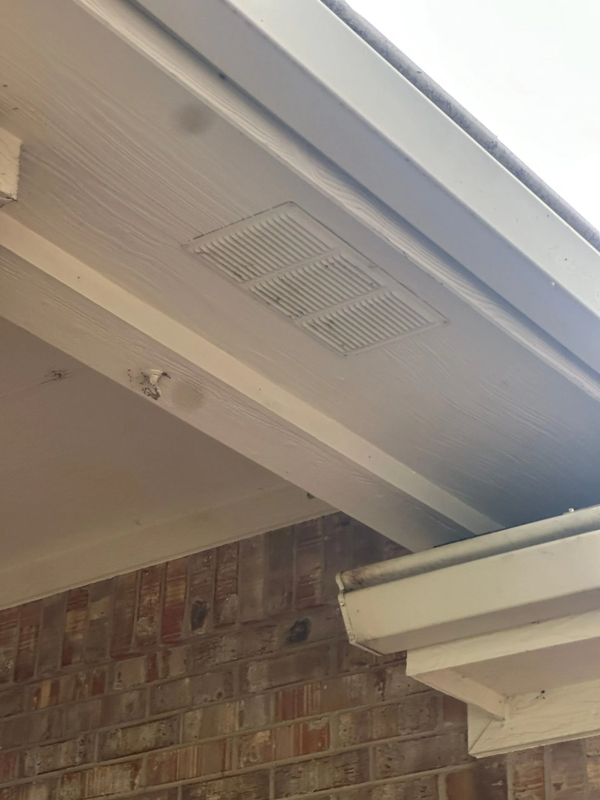 Close-up of a fiber cement soffit panel with a louvered vent on a Driftwood project in Austin.