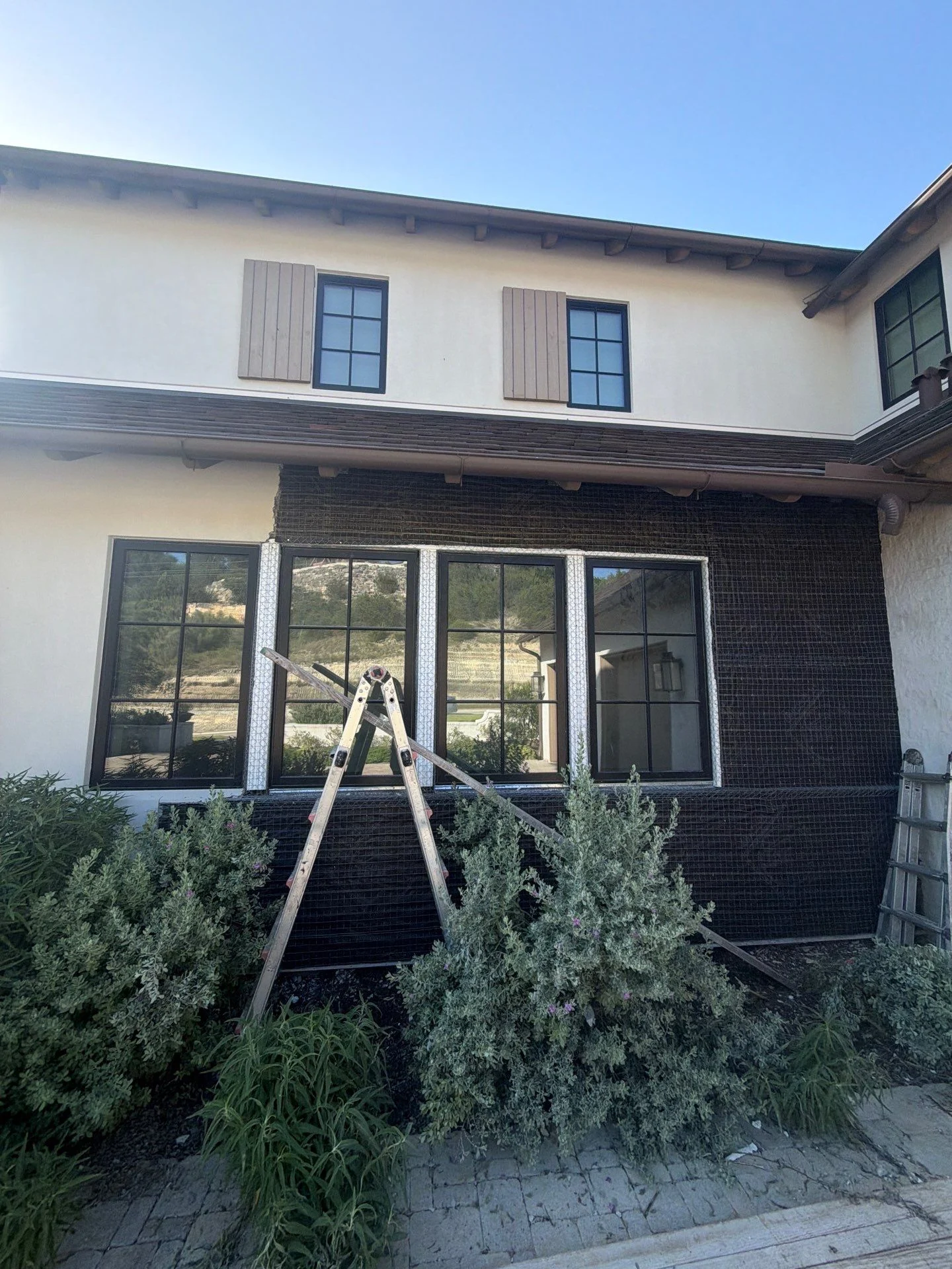 Stucco wall stripped down to the metal wire lath around window openings during a Driftwood exterior restoration in Westlake, Austin.