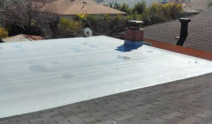 images 3 - Driftwood Builders Roofing - Driftwood Builders Roofing Flat roof with fresh white coating, brick chimney and vent pipes, satellite dish in background.