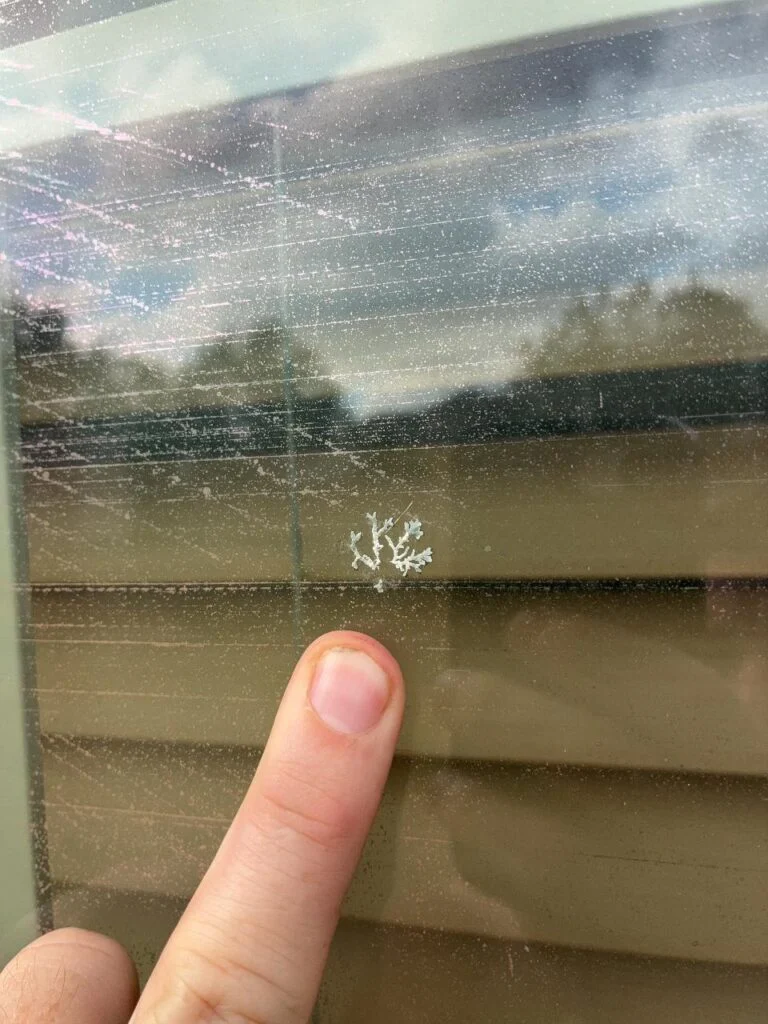 Star-shaped hail impact fracture in a window pane, pointed out during a Converse, TX inspection