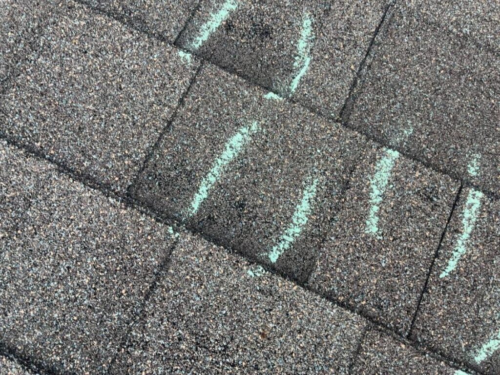Hail impacts marked in chalk across asphalt shingle courses on a Schertz, TX roof
