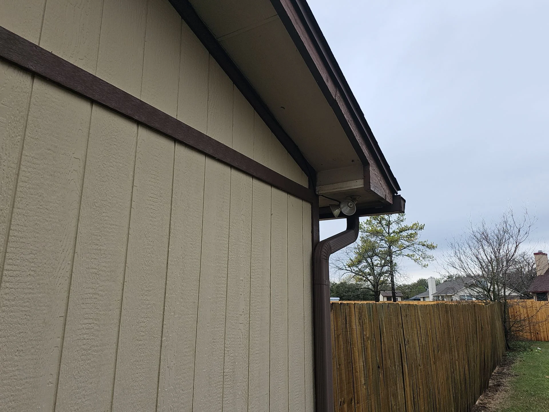 Wire mesh screening installed over a triangular roofline vent opening to block animal entry, real exclusion work at Driftwood Builders Roofing's own office building in Manchaca, TX