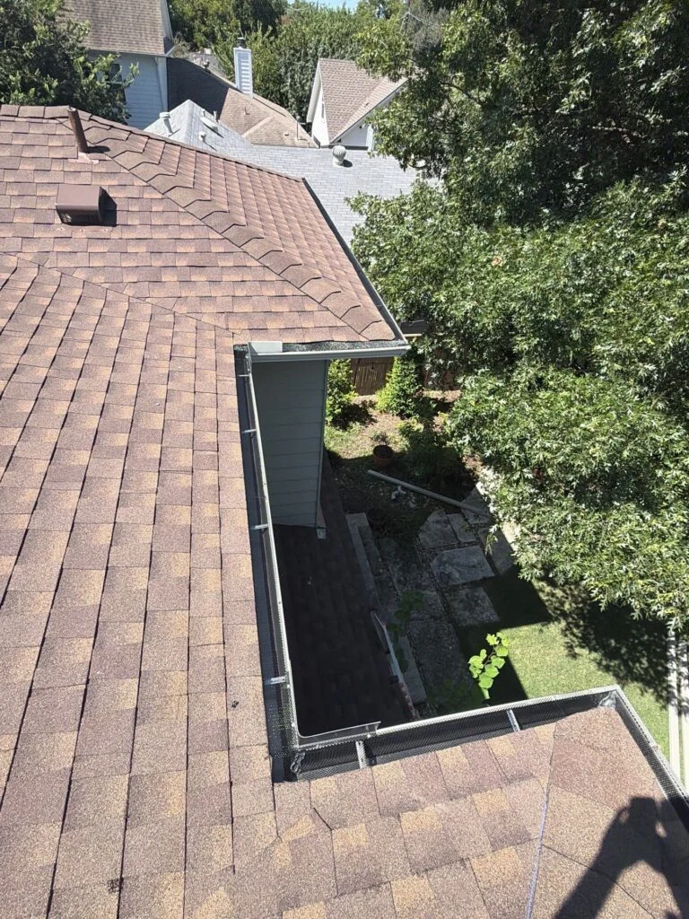A gutter wrapping an inside corner below where two roof planes meet on an Austin home